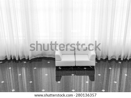 Modern sofa reflected on tiling with large curtain in black and white