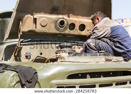 UFA/BASHKORTOSTAN - RUSSIA 30th May 2015 - Closeup of a road repair worker in Ufa Russia fixing a broken down vehicle on the main prospect in the hot summer sun of Bashkortostan
