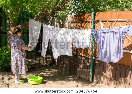 UFA/BASHKORTOSTAN - RUSSIA 30th May 2015 - Old pensioner woman making the most of a hot summer hanging up her washing in Ufa Russia
