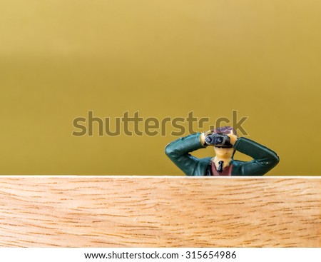 Single male model looking through binoculars secretly spies on an unknown person or event with copy space room
