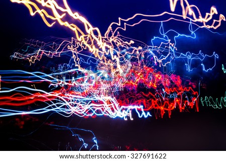 Multicolored light streaks from Neon, Sodium, and LED lights from an Urban street in a modern city. Black background and lightpainting trails create an abstract effect.