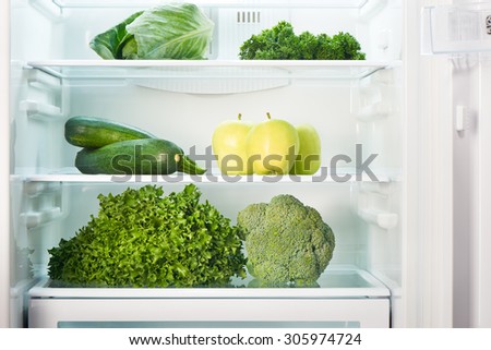 Open refrigerator full of green fruits and vegetables. Weight loss diet concept.