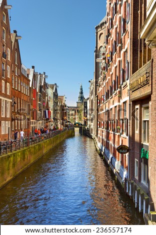 AMSTERDAM - APRIL 30: Canal with traditional old buildings the Netherlands during the celebration of kings day on April 30, 2012 in Amsterdam, The Netherlands