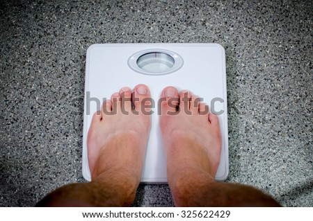 Weight Gain/Weight Loss Concept Feet Standing on Scale