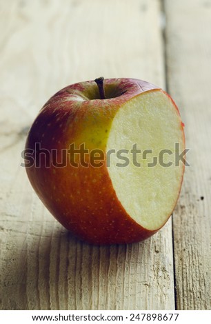 Red cut apple, over rustic wooden table