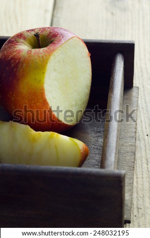 Red cut apple in a wooden box over wooden table