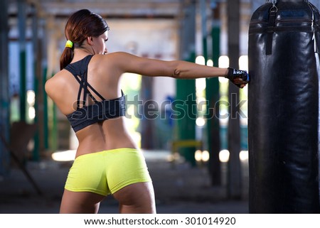 sexy girl punching boxing bag
