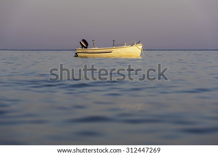 fisherman boat in calm sea water in sunset light at water level
