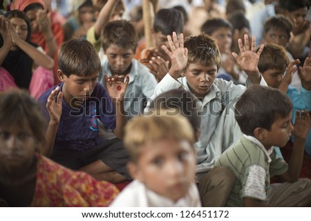 LAHORE, PAKISTAN- AUG 2 2012: Unidentified children in a slum prayed for better future of the community on August 2 2012 in Lahore, Pakistan. Children in Pakistan suffer from poor education.