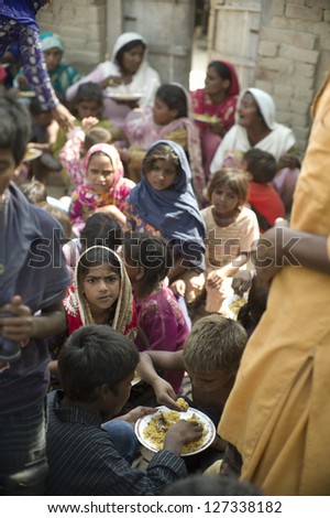 LAHORE, PAKISTAN- AUG 2 : Unidentified children in brick kiln wait for the food from relief team on August 2 2012 in Lahore, Pakistan. Children in Pakistan suffer from malnutrition.