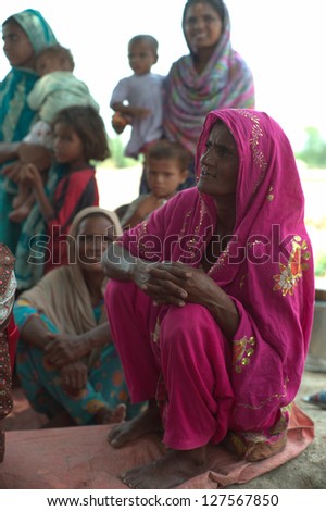 LAHORE, PAKISTAN- AUG 2: Unidentified people and children in brick kiln are waiting for the food from relief team on August 2, 2012 in Lahore, Pakistan. Malnutrition is a common problem in Pakistan.