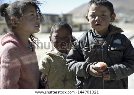Shigatse,China-OCT 11:Unidentified children feel excited when the relief team gives them fruit on October 11,2011 in Shigatse,China.Children in rural Tibet do not received enough food and education.