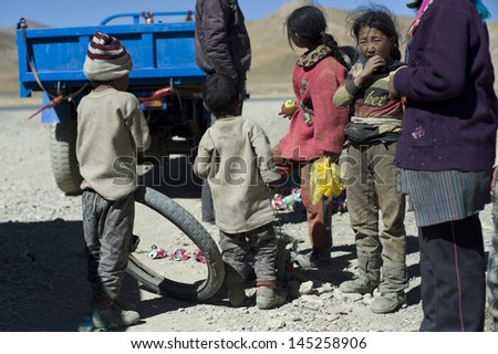 SHIGATSE,CHINA-OCT 11:Unidentified children feel excited when the relief team gives them fruit on October 11,2011 in Shigatse,China.Children in rural Tibet do not received enough food and education.