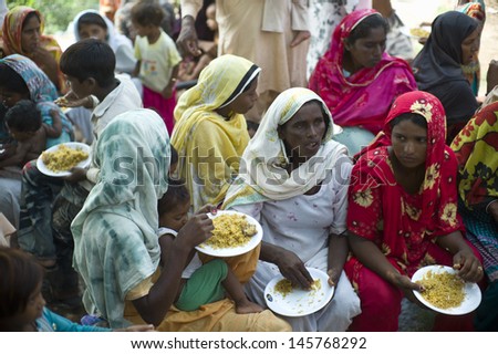 LAHORE, PAKISTAN- AUG 2: Unidentified women in brick kiln are having food from relief team on August 2, 2012 in Lahore, Pakistan. Malnutrition is a common problem in Pakistan.
