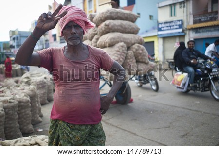 TRICHY, INDIA - AUG 3: Unidentified Indian man is transporting onion in market on August 3, 2012 in Trichy, India. Amongst the onion producing countries, India ranks second in area and production.
