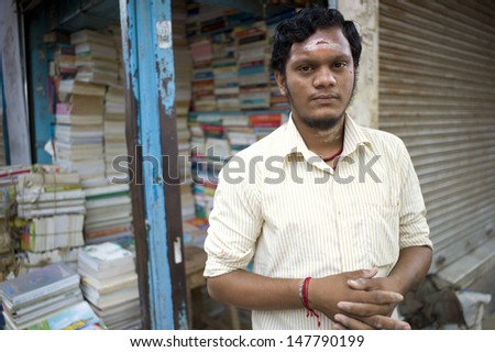 TRICHY, INDIA - AUG 15: An unidentified book seller sells exam reference books in a small street book shop on August 15, 2011 in Trichy, India. Indians are keen on taking exams to equip themselves.