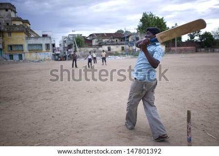 TRICHY, INDIA - 16 AUG: A group of high school students have a cricket game on the school playground on July 16, 2008. Cricket is a national game of India, where everyone loves this sport.