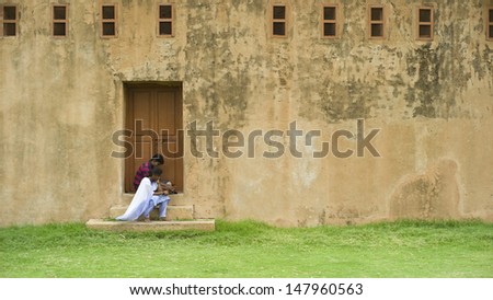 THANJAVUR, INDIA - AUG 23; A pair of couple are resting in the ancient Brihadisvara Temple on August 23 2012 in Thanjavur India.Brihadisvara Temple is one of the oldest temple in India.