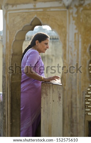 AMER, INDIA - NOV. 19: Unidentified indian woman in brightly colored sari visits the Amber palace on November 19,2012 in Amer,India. Amer Fort is famous for artistic style of Hindu elements.