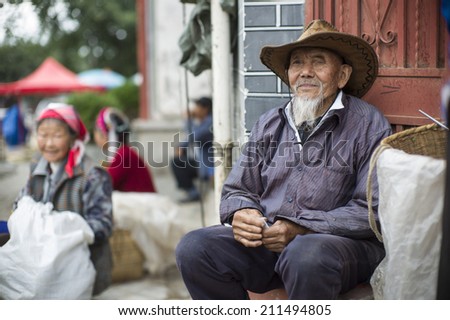 DALI, CHINA - MAY 15: An old man is selling tea in the flea market on the street in Dali, China on May 15 2014. He is from a minority ethnic, called Bai.
