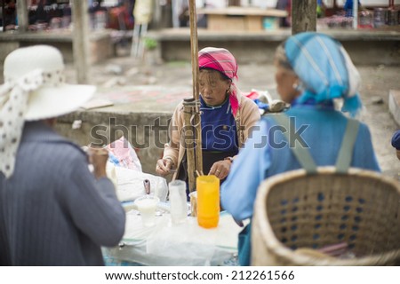 DALI, CHINA - MAY 15: An old woman is selling local breakfast in the flea market on the street in Dali, China on May 15 2014. Yunnan is famous for tea.