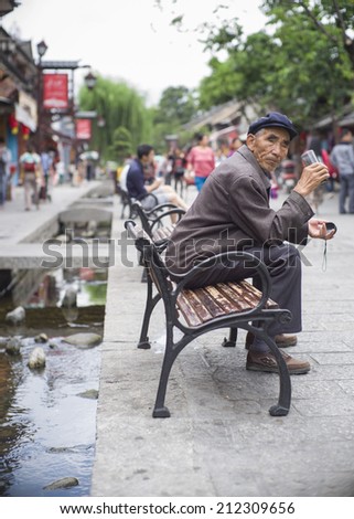DALI, CHINA - MAY14 : A local, from Bai ethnics, on the street located in Dali Old City, Yunnan, China on May 14 2014. Dali is now a major tourist destination for domestic and international tourists
