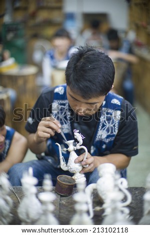 DALI, CHINA - MAY 16: A worker is using traditional method to process handmade silver craft in Dali, China on May 16 2014. Silver is a famous product in Dali, Yunan.