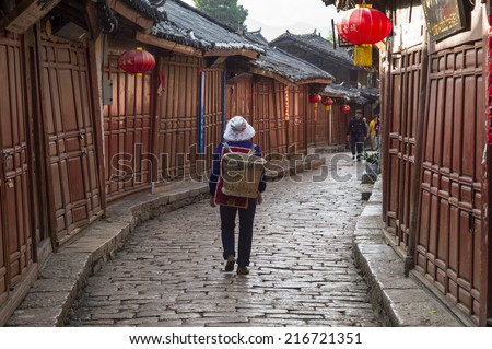 LIJIANG, CHINA - MAY 16: The unidentified person is walking in the famous LiJiang Old City, China on May 16 2014. Lijiang is one of the biggest and well-preserved old town in China.
