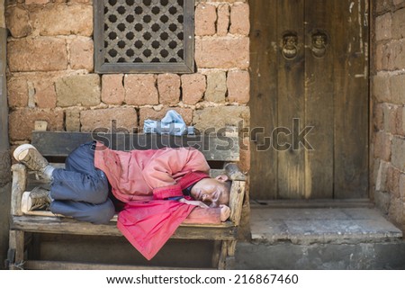 LIJIANG, CHINA - MAY 16: The unidentified person is sleeping on the street in the famous LiJiang Old City, China on May 16 2014. Lijiang is one of the biggest and well-preserved old town in China.