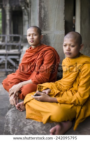 SIEM REAP, CAMBODIA - NOV 16: Buddhist monks in yellow robes visiting one of the famous temples of Angkor Wat, Siem Reap, Cambodia on November 16 2014.