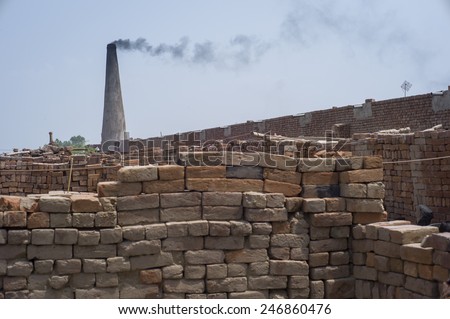 LAHORE, PAKISTAN- AUG 1 2012: The chimney in a brick kiln on August 1 2012 in Lahore, Pakistan. People are exploited in the brick kiln and they suffer from poor health.