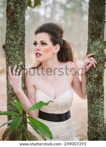 Bride staring out between two trees looking for her love/groom
