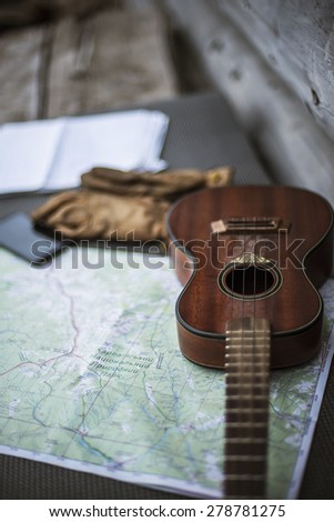 tourist still life - guitar, map, gloves, phone on old wooden background