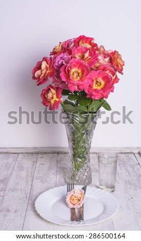 table setting with roses bouquet on vintage white background
