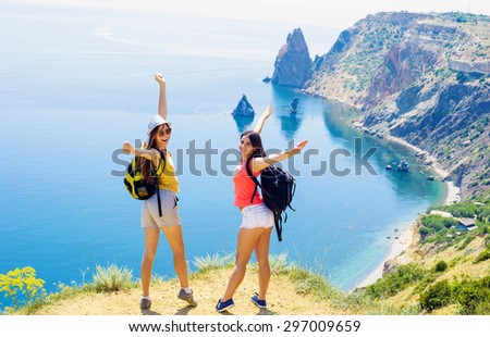 two young caucasian females hiking on a cliff above the sea
