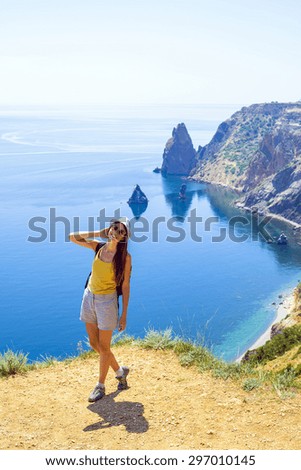 young caucasian female hiking on a cliff above the sea