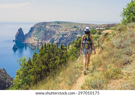 young caucasian female hiking on a cliff above the sea