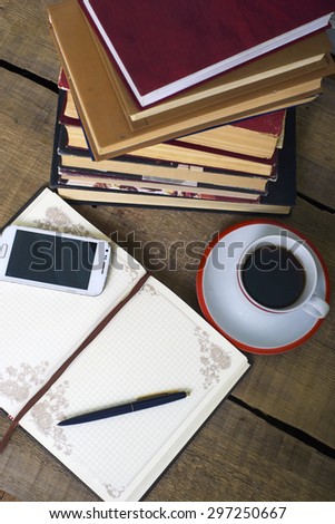 books, notepad, cellphone and coffee cup on wooden background. Education concept
