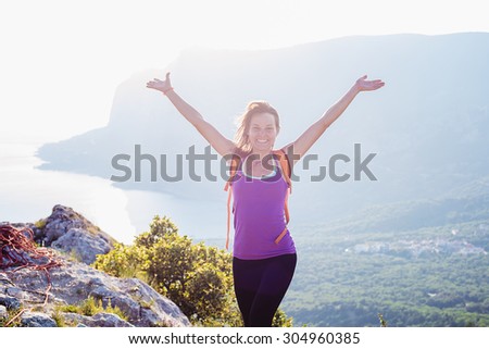 free happy caucasian female standing on the top of mountain with cheering handsactive and healthy woman hiking in mountains in crimea