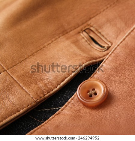 Luxury leather jacket, light brown color and closeup detail on sewing and button.