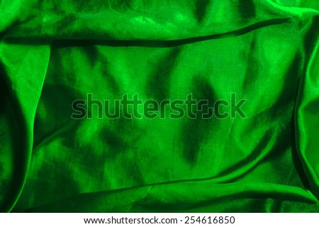green background abstract cloth of wavy folds of silk texture satin or velvet material or  wallpaper design of elegant curves green material