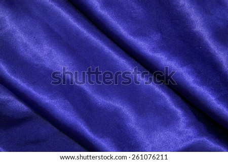 blue background abstract cloth of wavy folds of silk texture satin or velvet material or design of elegant curves blue material