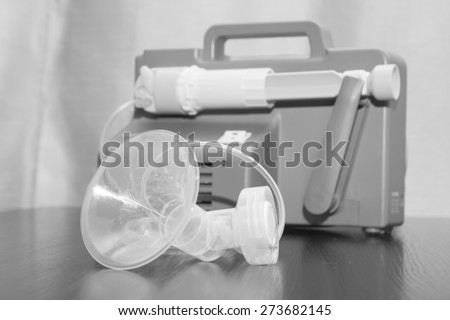Close up on a old breast pump . A breast pump is a mechanical device that extracts milk from the breasts of a lactating woman.