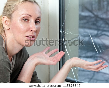 The housewife is upset,  the bad quality double-glazed window has burst because of a frost