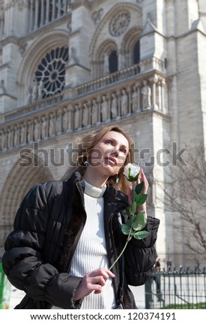 The beautiful woman with a rose before Notre Dame de Paris