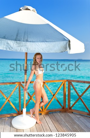 Young woman  on a water villa terrace , Maldives
