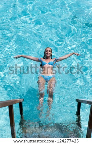 Young sports woman swims from steps