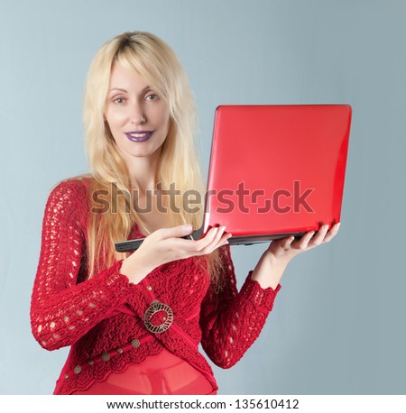 The young beautiful woman in  red blouse  with the red laptop