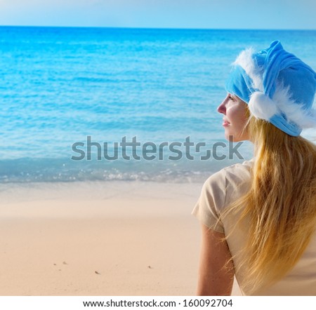 The woman in New Year\'s Santa-Klaus cap on background of ocean.