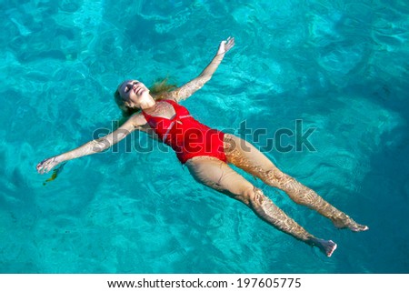 The sports girl swims in the sea